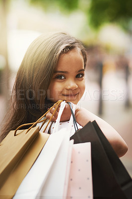 Buy stock photo Portrait of an adorable little girl holding shopping bags while out in the city