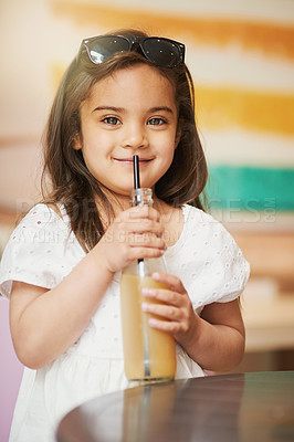 Buy stock photo Shot of an adorable little girl enjoying a cold drink in a cafe