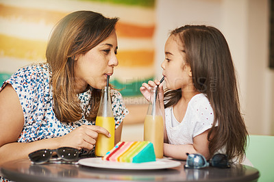 Buy stock photo Cropped shot of a mother and her little daughter enjoying a cold drink in a cafe