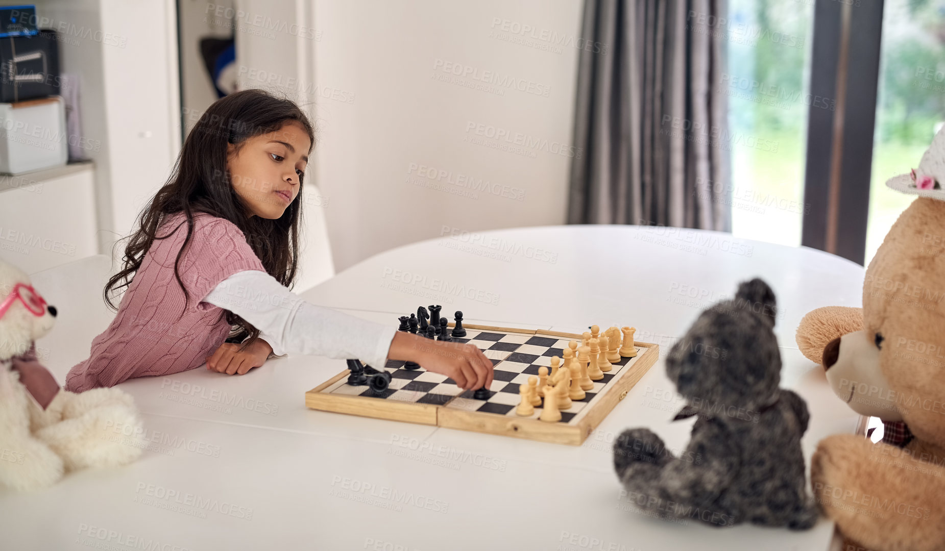 Buy stock photo Cropped shot of a little girl playing chess with her teddy bears at home