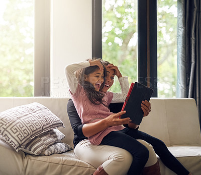 Buy stock photo Cropped shot of a mother and daughter using a digital tablet together at home