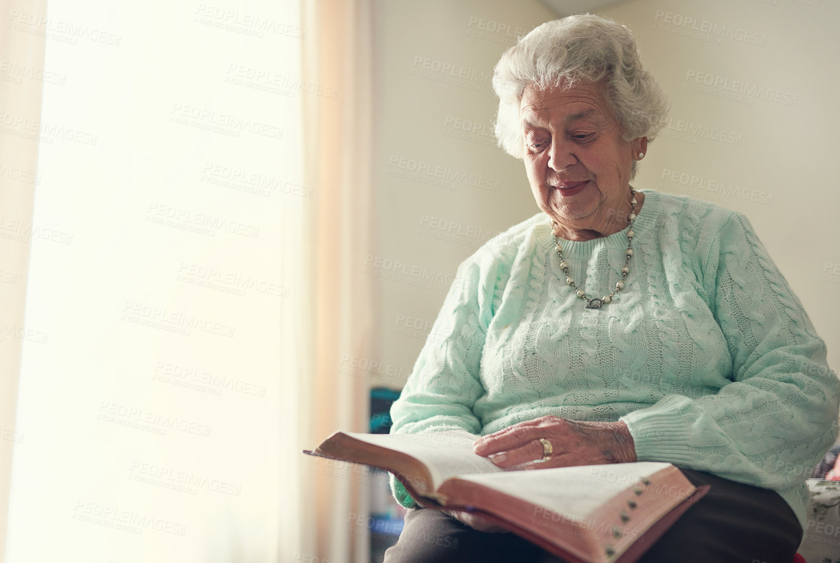 Buy stock photo Cropped shot of a senior woman reading a bible