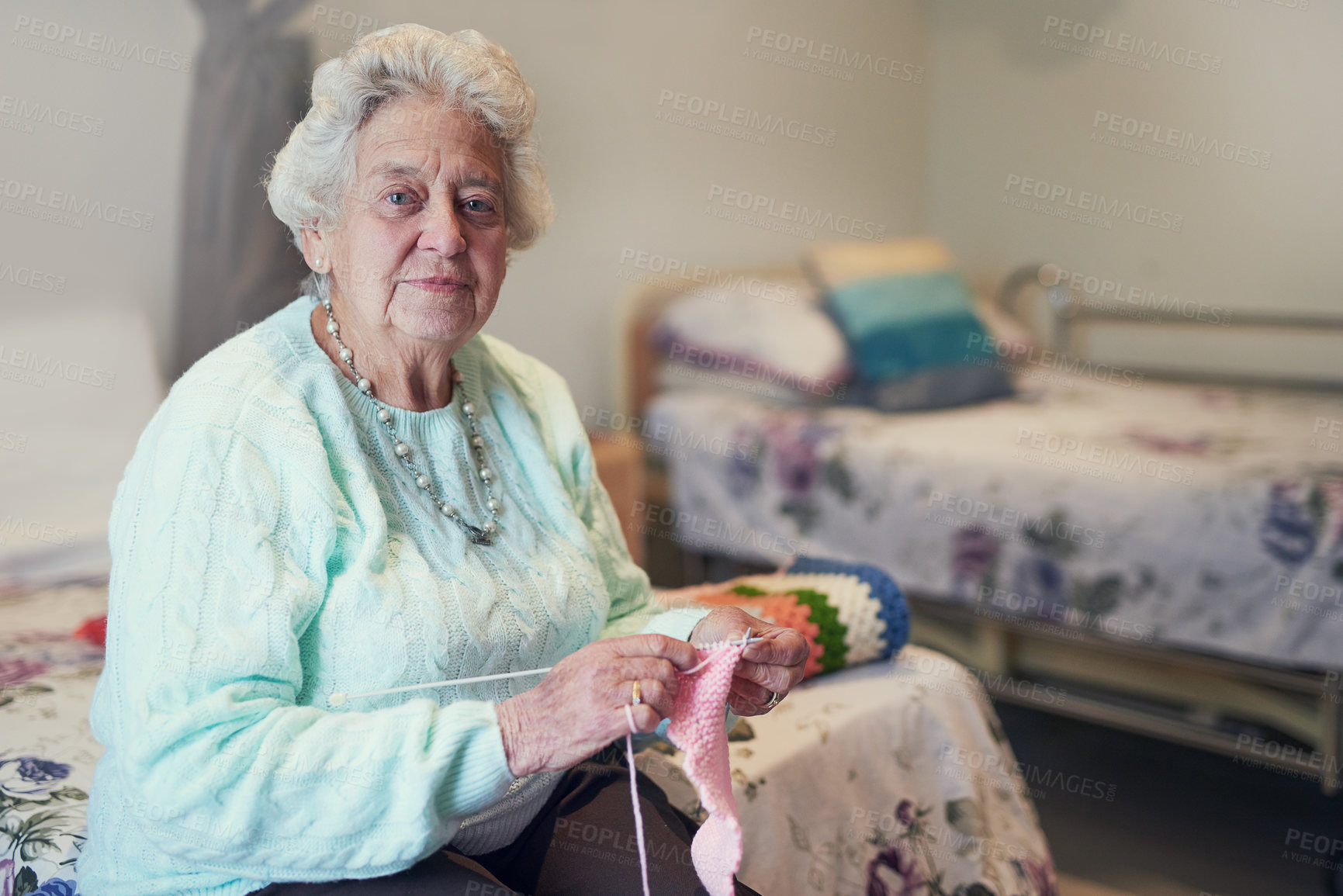 Buy stock photo Portrait of a senior woman knitting in an old age home