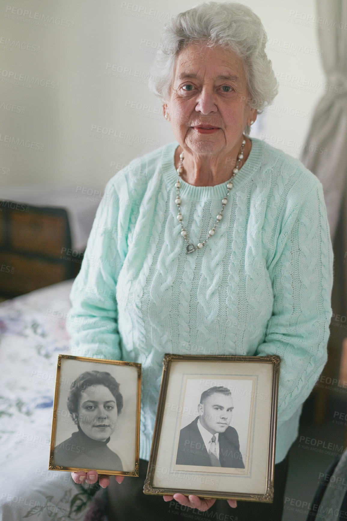 Buy stock photo Portrait of a senior woman holding old black and white photos of a man and a woman