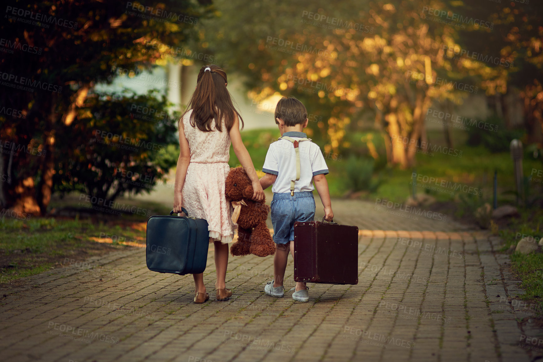 Buy stock photo Shot of a little girl and her brother walking away while carrying suitcases and toys