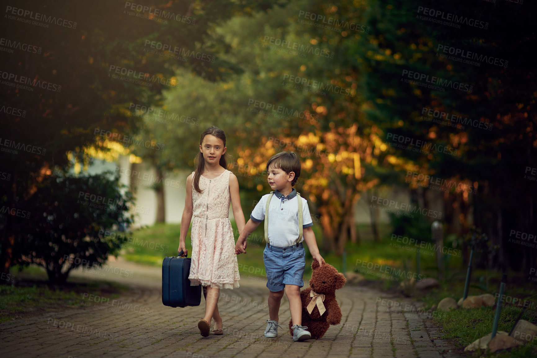 Buy stock photo Shot of a little girl and her brother walking while carrying suitcases and toys