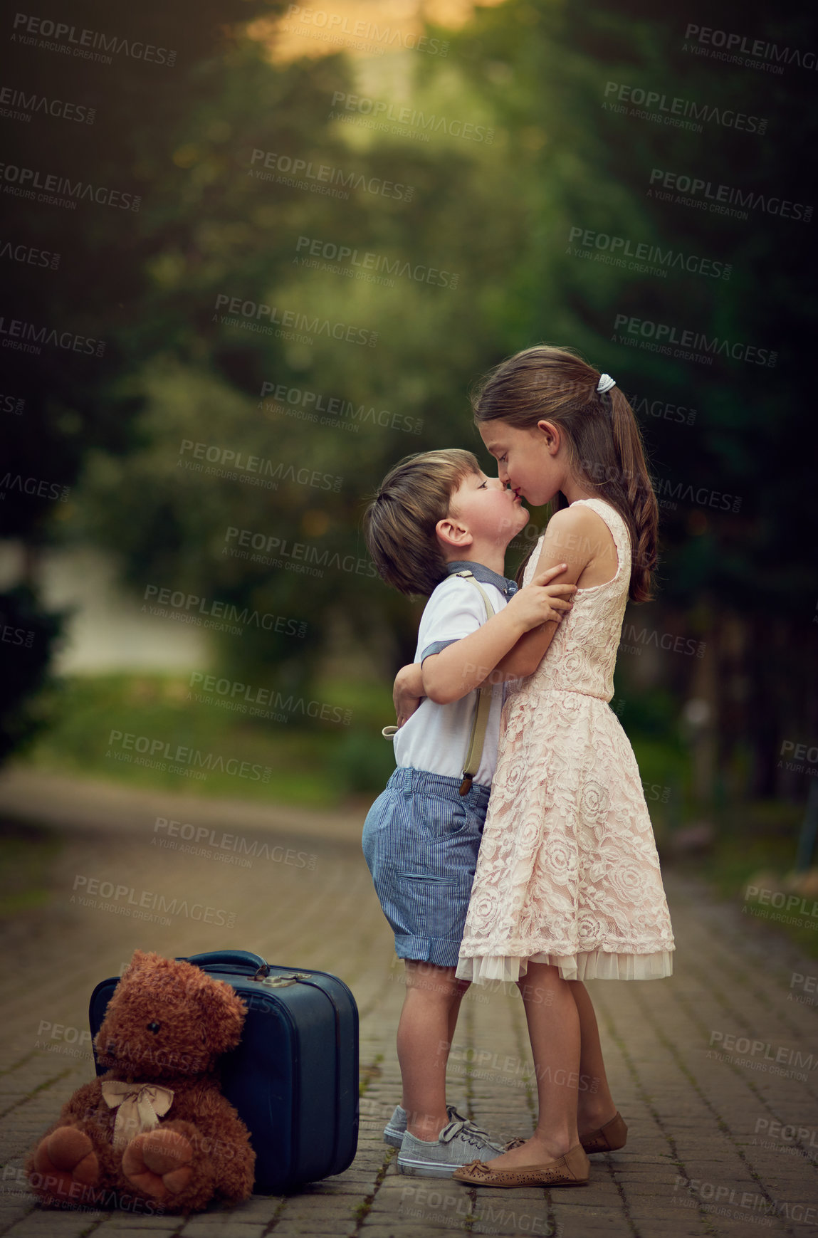 Buy stock photo Shot of a cute little girl kissing her little brother while they play outside