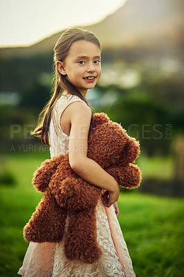 Buy stock photo Portrait of a cute little girl playing with her teddybear outside