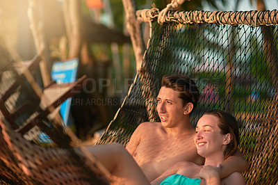 Buy stock photo Cropped shot of a young couple relaxing on a hammock at the beach