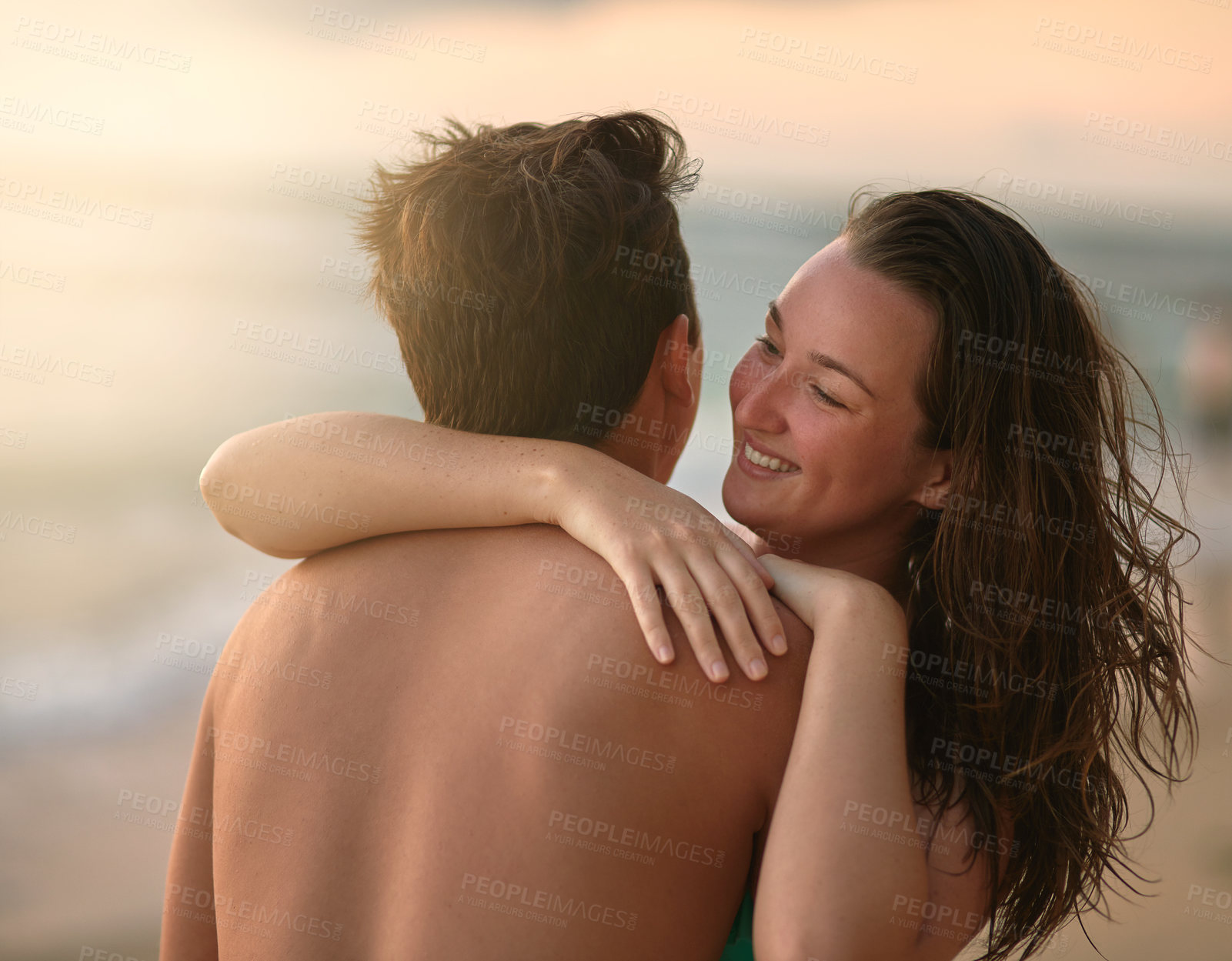 Buy stock photo Cropped shot of an affectionate young couple enjoying the day at the beach