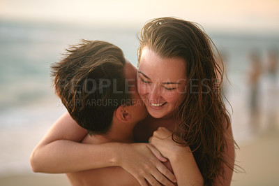Buy stock photo Cropped shot of an affectionate young couple enjoying the day at the beach