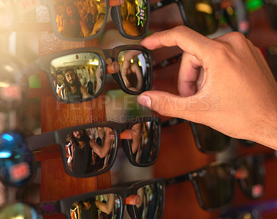 Buy stock photo Cropped shot of a man trying on sunglasses at a stall