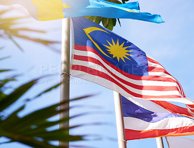 Buy stock photo Shot of a Malaysian and Thailand flag blowing in the wind
