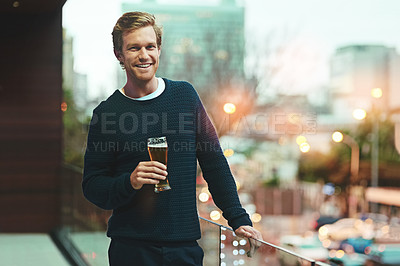 Buy stock photo Portrait of a young man relaxing on a balcony while enjoying a beer
