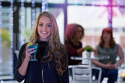 Buy stock photo Portrait of a happy young woman enjoying a cocktail in a nightclub