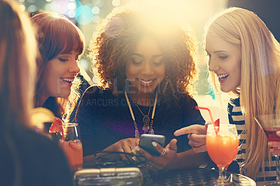 Buy stock photo Shot of a group of happy friends enjoying cocktails in a nightclub