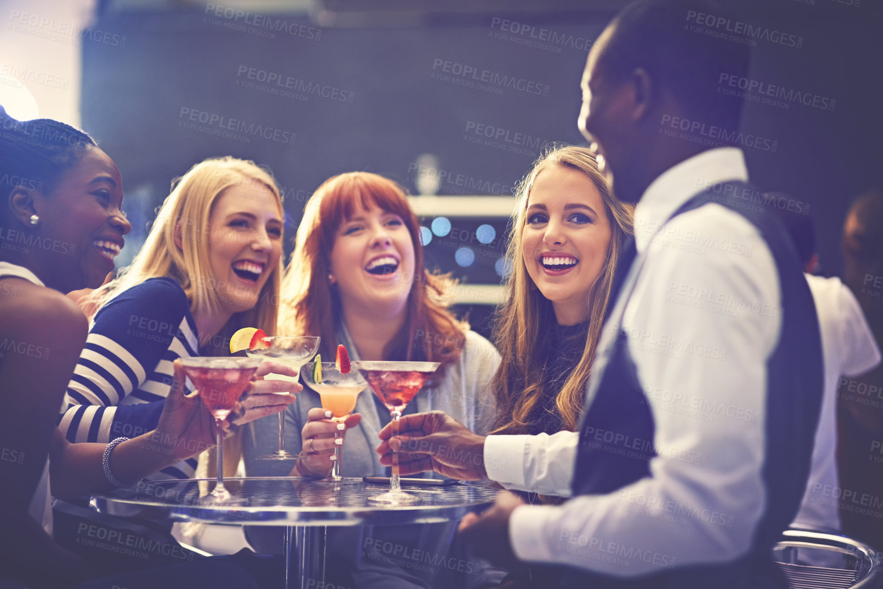 Buy stock photo Shot of a cocktail waiter serving drinks to a group of friends in a nightclub