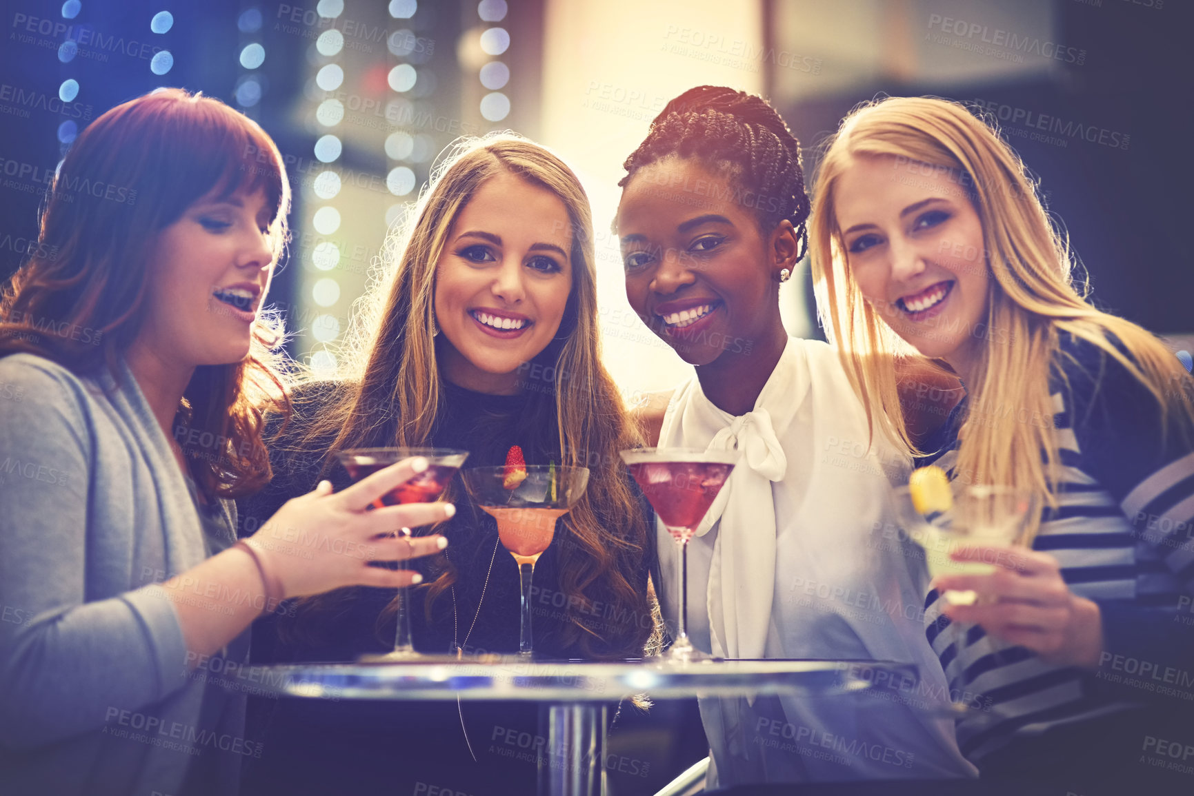 Buy stock photo Portrait of a group of happy friends enjoying cocktails in a nightclub
