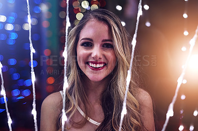 Buy stock photo Portrait of a happy young woman playing with string lights in a night club