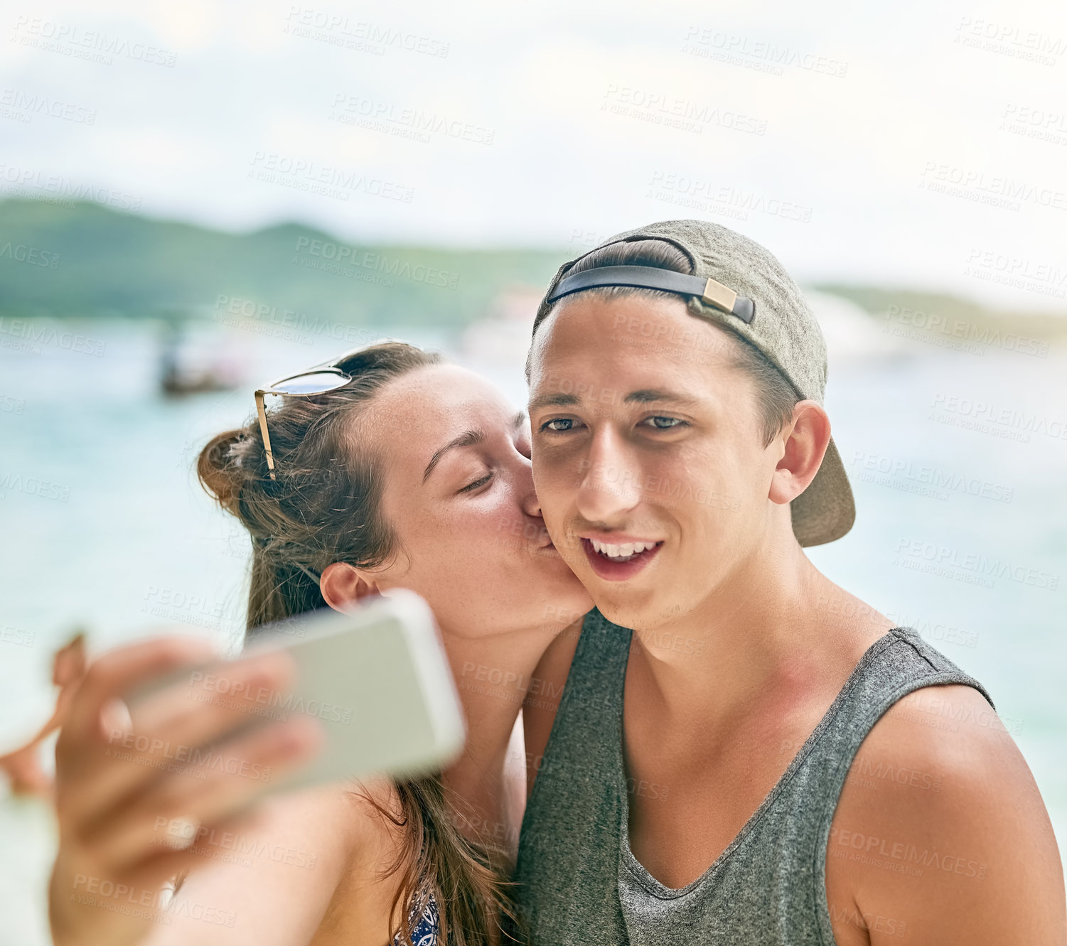 Buy stock photo Shot of a happy couple taking a selfie on the beach