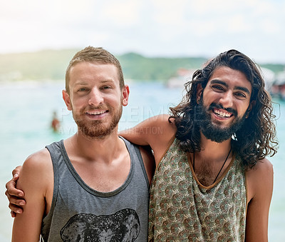 Buy stock photo Portrait of two male friends enjoying a day at the beach while on vacation