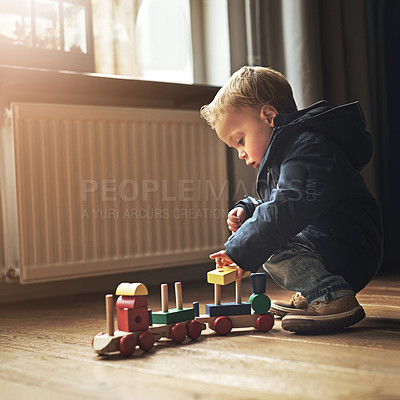 Buy stock photo Sweet, playing and boy child with toys for learning, fun and sensory development at home. Cute, youth and kid or toddler with wooden blocks for building train on floor in living room at house.