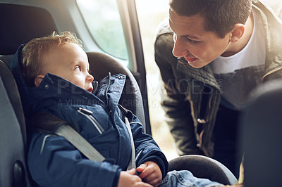 Buy stock photo Cropped shot of a father putting his little son in a car seat
