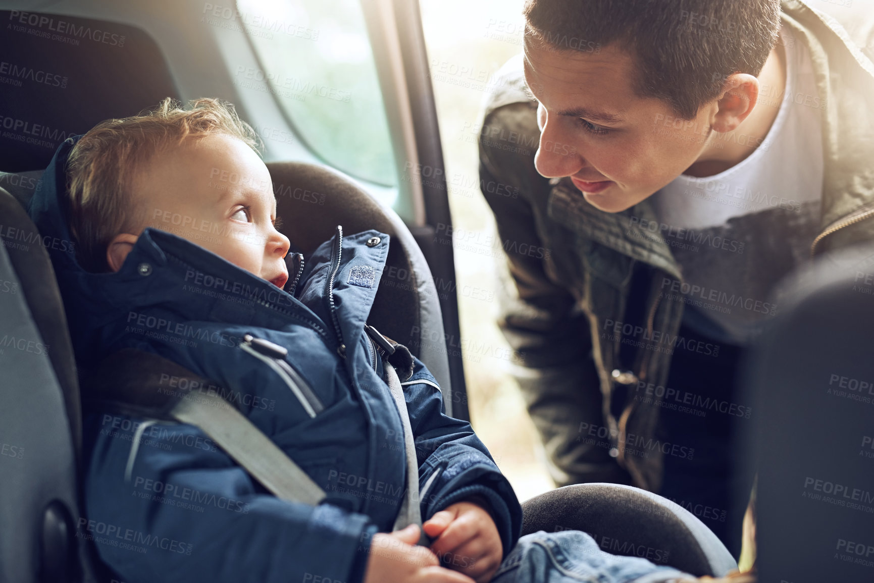 Buy stock photo Cropped shot of a father putting his little son in a car seat