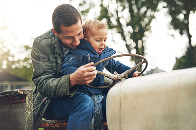 Buy stock photo Cropped shot of a father and his little son playing together on a farm tractor outside
