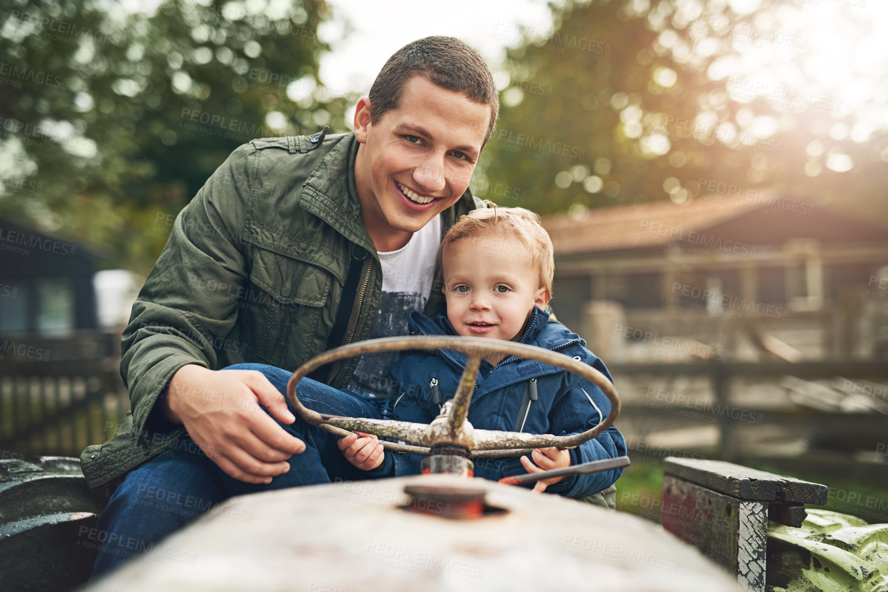 Buy stock photo Portrait of a father and his little son playing together on a farm tractor outside