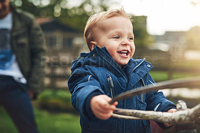Buy stock photo Cropped shot of an adorable little boy playing on a farm tractor outside