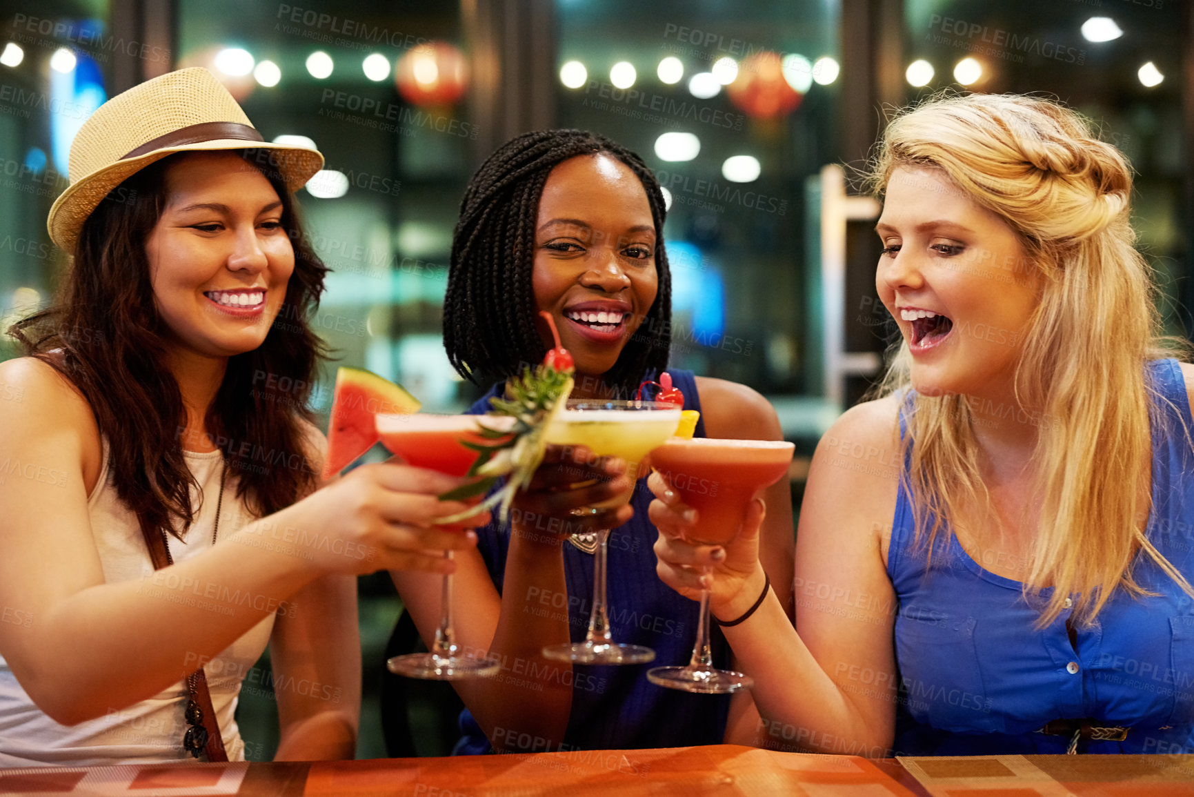 Buy stock photo Cropped shot of three young girlfriends toasting in a bar
