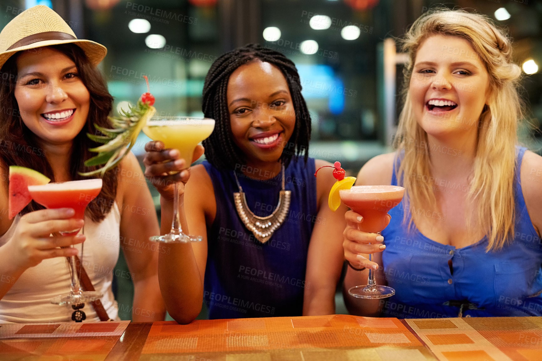 Buy stock photo Cropped portrait of three young girlfriends having drinks at a bar