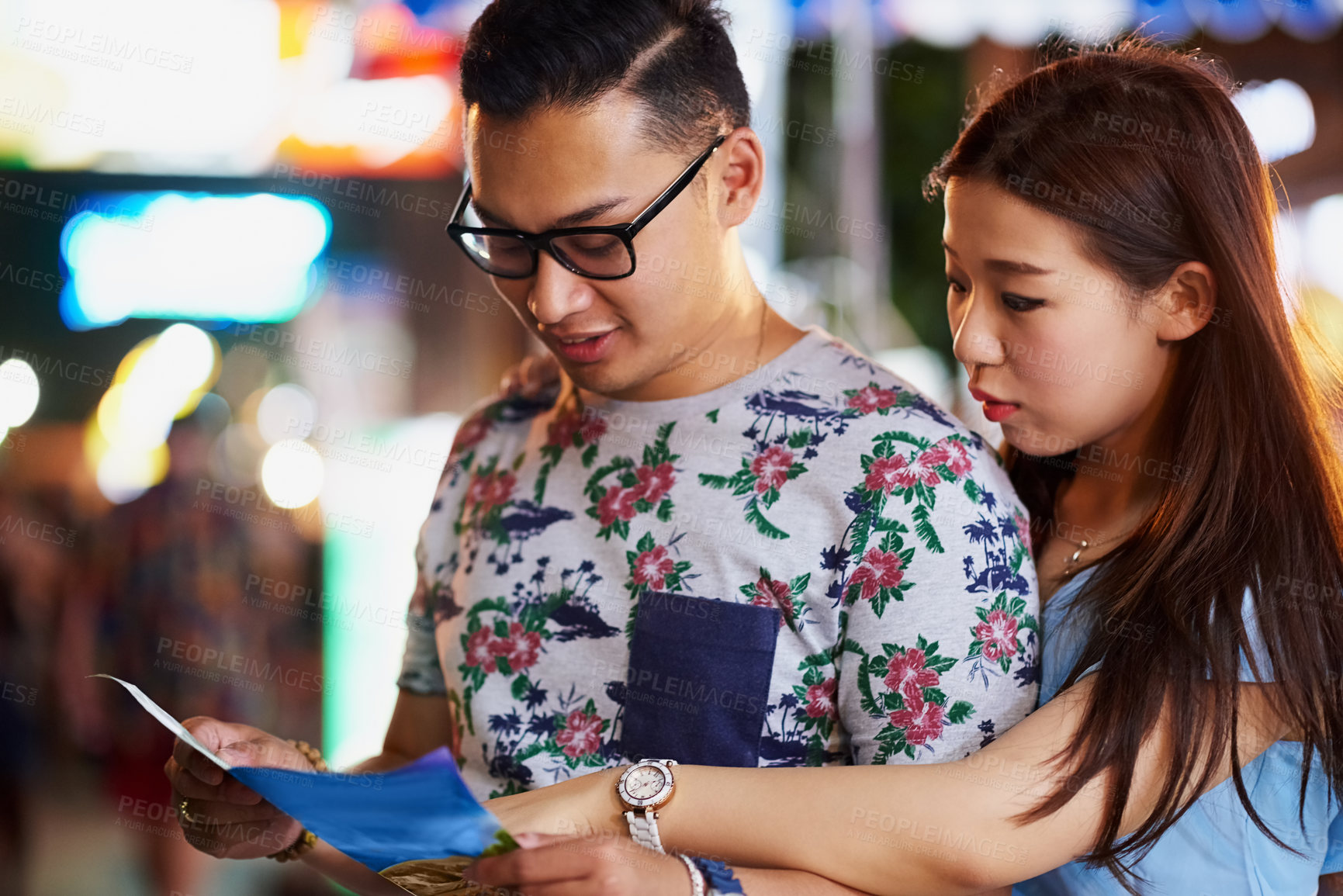 Buy stock photo Cropped shot of a young couple looking at a map while out in the city