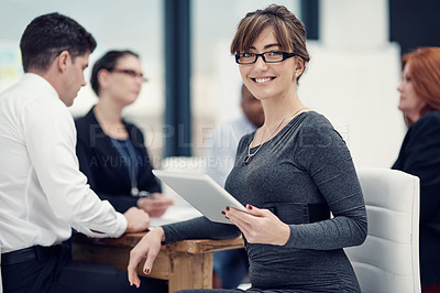 Buy stock photo Portrait of a businesswoman using a digital tablet during a meeting with her colleagues