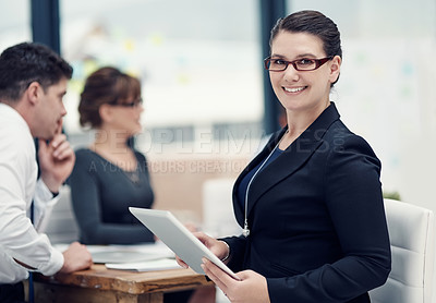 Buy stock photo Portrait of a businesswoman using a digital tablet during a meeting with her colleagues