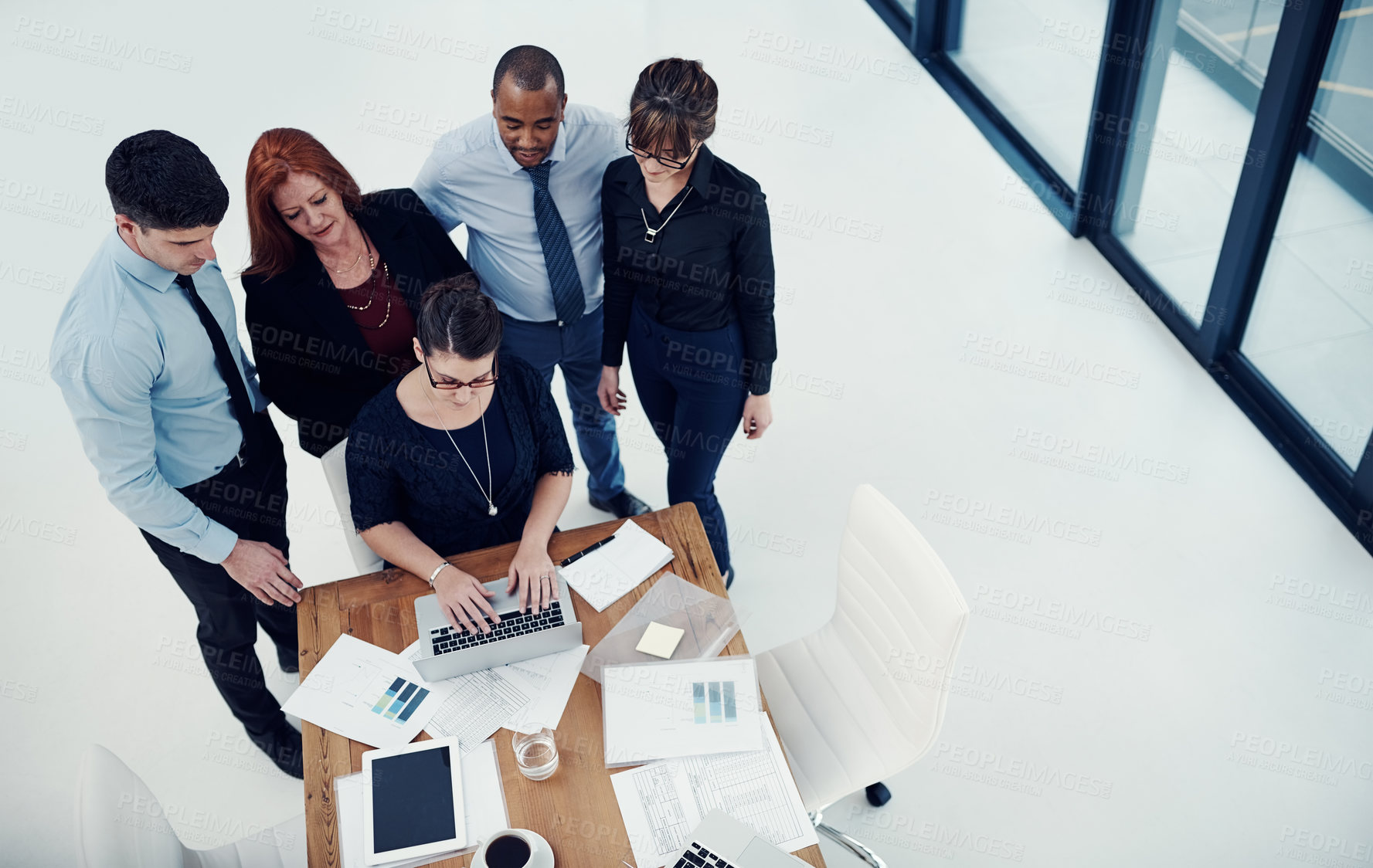 Buy stock photo Shot of group of businesspeople using a laptop together during a meeting in an office