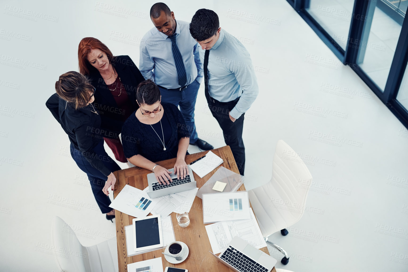 Buy stock photo Shot of group of businesspeople using a laptop together during a meeting in an office