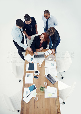 Buy stock photo Shot of group of businesspeople using a laptop together during a meeting in an office