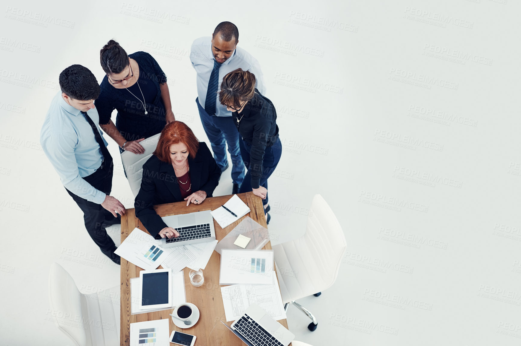 Buy stock photo Shot of group of businesspeople using a laptop together during a meeting in an office