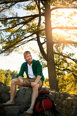 Buy stock photo Shot of a handsome young man hiking while on an overseas trip