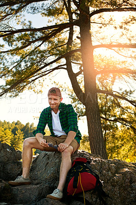 Buy stock photo Shot of a handsome young man hiking while on an overseas trip