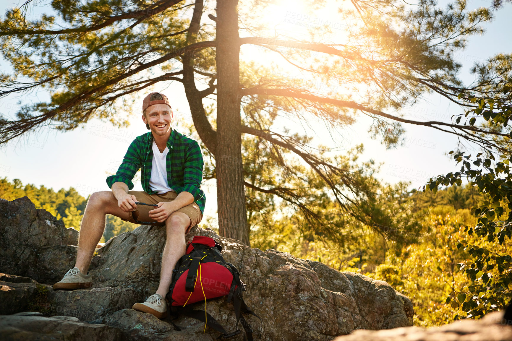 Buy stock photo Shot of a handsome young man hiking while on an overseas trip