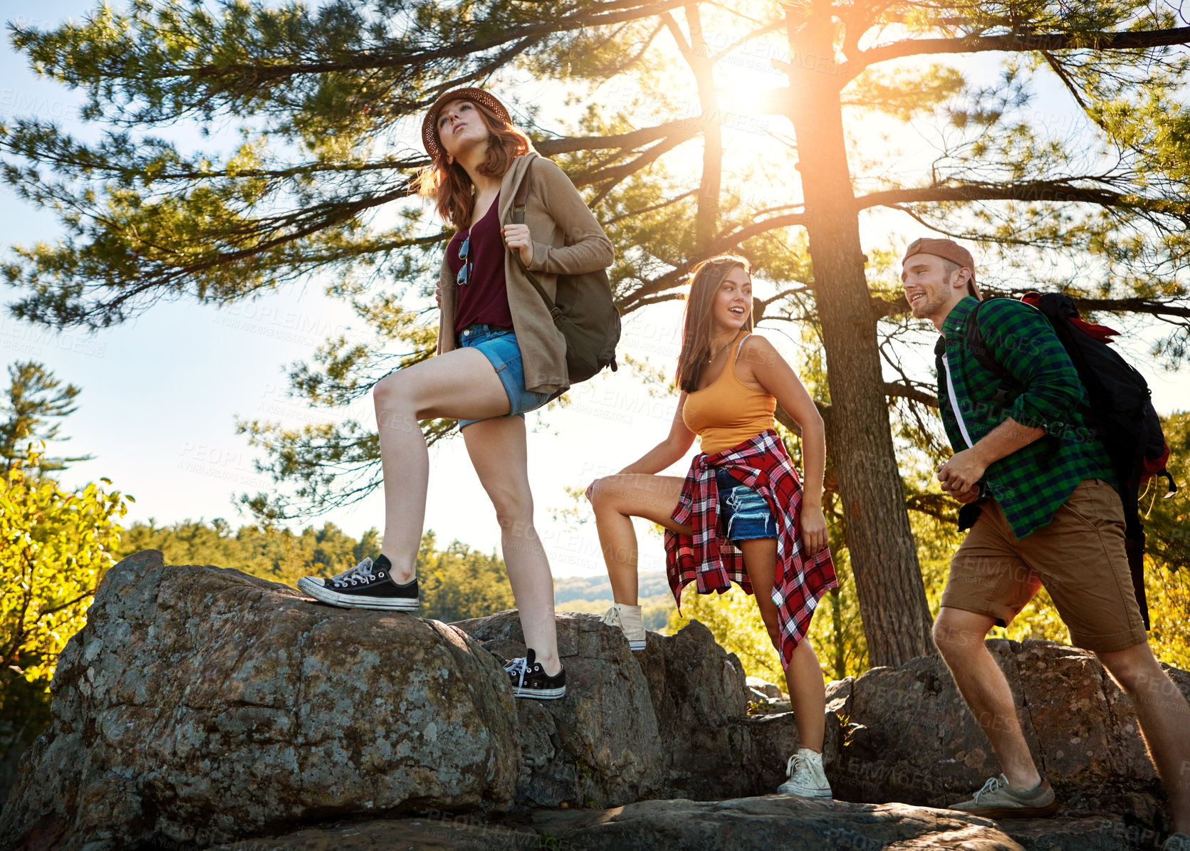 Buy stock photo Shot of three young people hiking while on an overseas trip