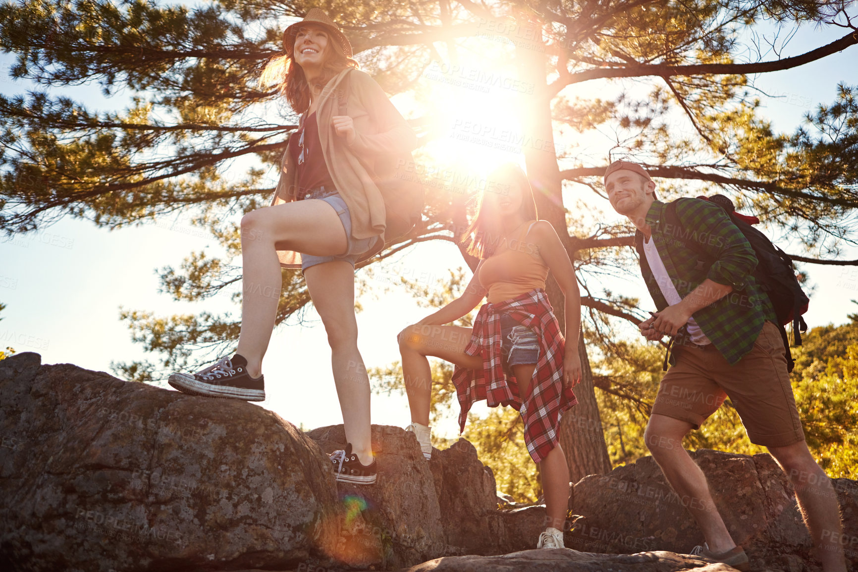 Buy stock photo Shot of three young people hiking while on an overseas trip