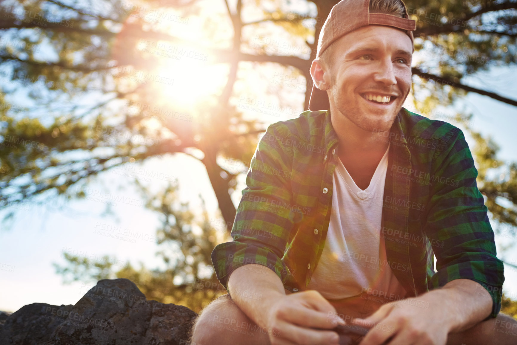 Buy stock photo Shot of a handsome young man hiking while on an overseas trip