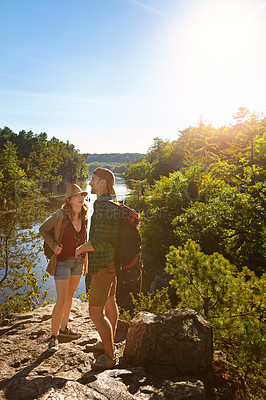 Buy stock photo Nature, hiking and couple at river on adventure holiday in mountain with trees, sun, and bush. Trekking, man and woman on travel vacation together in woods, forest or outdoor climbing park at lake.