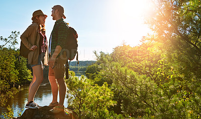 Buy stock photo Nature, hiking and couple on cliff at water on adventure holiday in mountain with trees, sun, and lake. Trekking, man and woman on travel vacation together at river, forest or outdoor climbing park