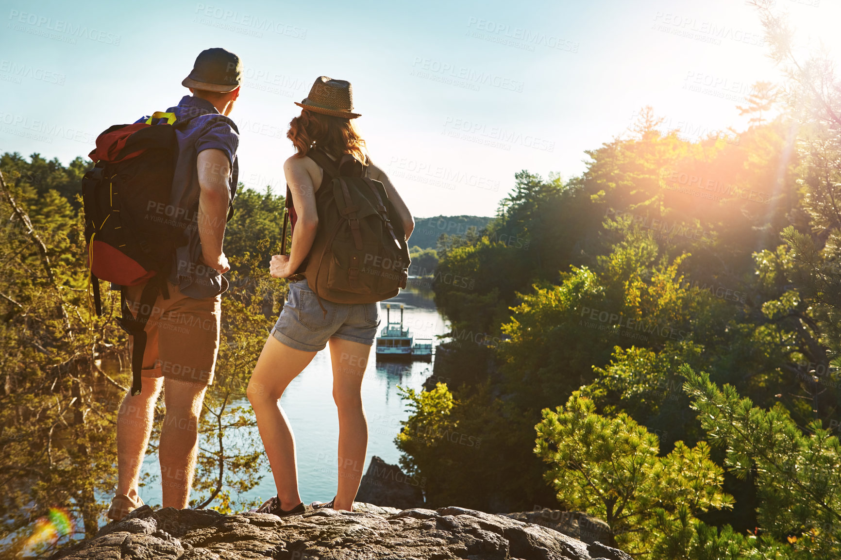 Buy stock photo Nature, hiking and couple at lake on adventure holiday in mountain with trees, sun, and bush from back. Trekking, man and woman on travel vacation together in woods, forest or outdoor climbing park