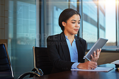 Buy stock photo Cropped shot of a businesswoman taking notes while using her tablet